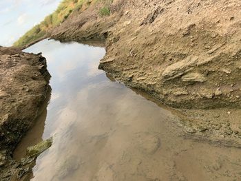 Rock formation on beach against sky