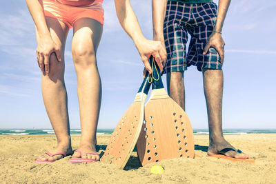 Low section of people standing at beach