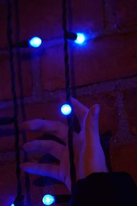 Close-up of hand holding illuminated lighting equipment