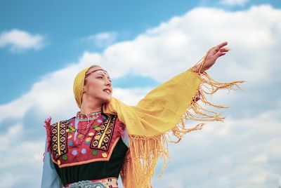 Low angle view of woman standing against sky