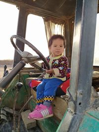 Portrait of smiling girl sitting on vehicle