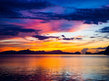 Scenic view of sea against dramatic sky during sunset in el nido, philippines 