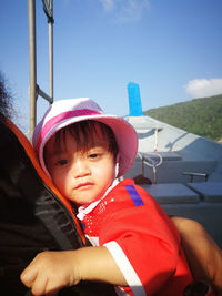 Portrait of cute baby girl wearing hat while sitting on boat