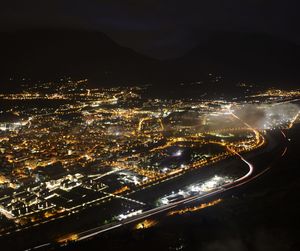 High angle view of illuminated city against sky at night
