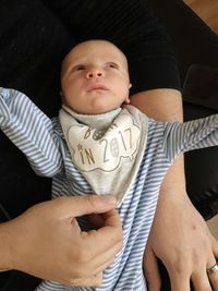 Cute newborn lying on lap of mother