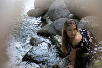Portrait of young woman with rock in water