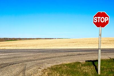 Stop sign against clear blue sky