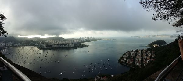 High angle view of cityscape by sea against sky