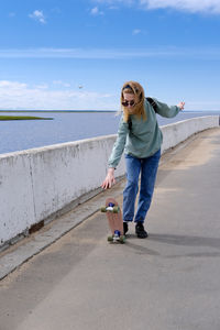 Portrait of young woman standing on promenade