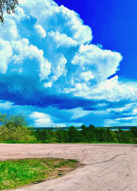 Road amidst field against sky