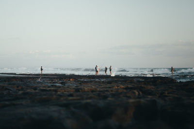 People on beach against sky