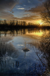 Scenic view of lake against sky at sunset