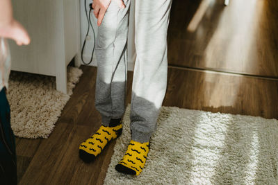 Low section of person standing on rug at home