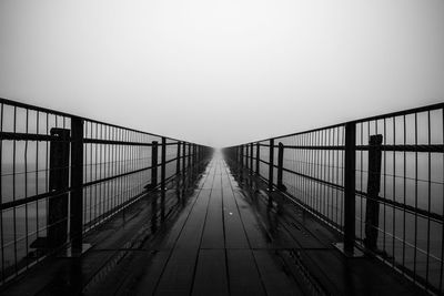 Empty footbridge against clear sky