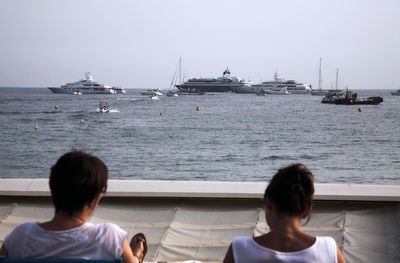 Rear view of women on beach against sky