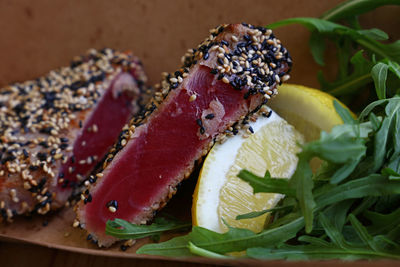 Close-up of seafood with herb and lemon slices in plate