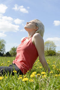 Midsection of woman on field against sky