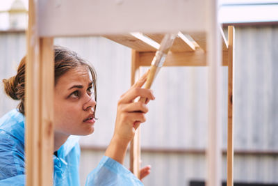 Portrait of young woman standing against wall