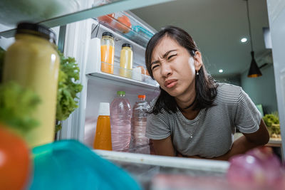 Young woman looking away while sitting on table