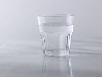 Glass of clear water on the gray background