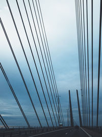 Low angle view of suspension bridge against sky