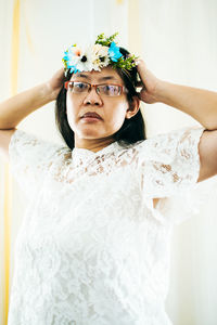 Portrait of woman wearing mask against blue wall