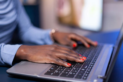 Midsection of woman using laptop