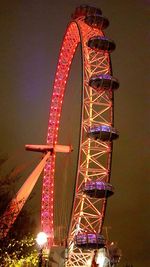 Low angle view of illuminated ferris wheel at night