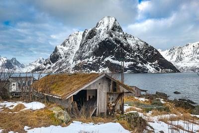 Built structure on snowcapped mountain against sky