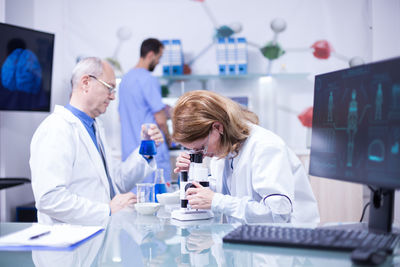 Female doctor examining chemical in laboratory