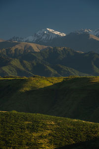 Scenic view of field by mountains against sky