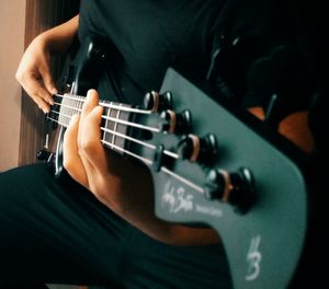 Midsection of man playing guitar