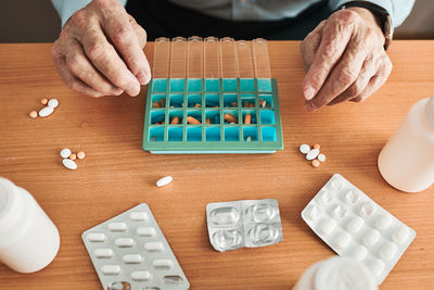 Senior man organizing his medication into pill dispenser. senior man taking pills from box