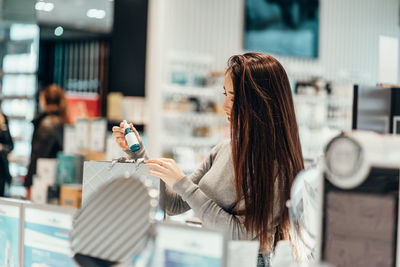 Woman holding umbrella at store