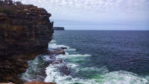 Scenic view of rocks in sea against sky