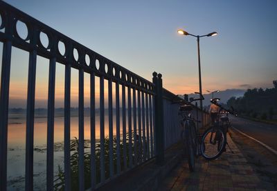 View of bicycle on bridge at sunset