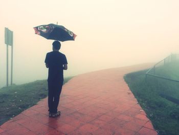 Full length of woman standing in foggy weather