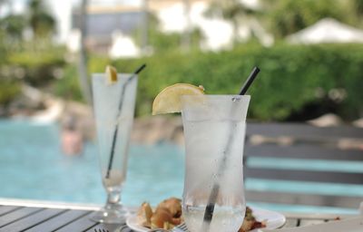 Close-up of drink on table against swimming pool