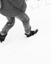 Low section of man standing on snow