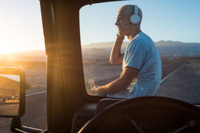 Side view of a young man sitting at bus