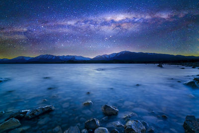 Scenic view of lake against sky at night