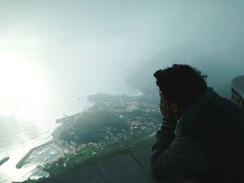 Man and woman by sea against sky