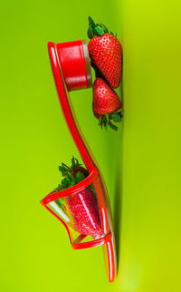 Close-up of strawberries in container against green background