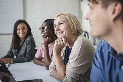 Smiling multi-ethnic business people listening in conference room during meeting