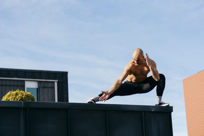 Athletic man doing parkour balance exercises outdoors in urban scene person