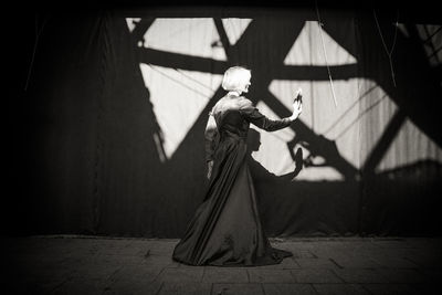 Low angle view of woman standing against wall