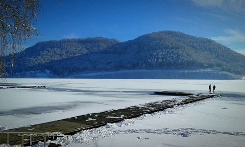 Scenic view of frozen lake against blue sky