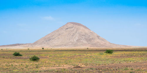 Scenic view of land and mountain against sky