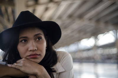 Close-up portrait of young woman wearing hat