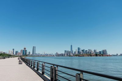 View of city buildings against clear blue sky